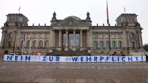 Une petite manifestation a eu lieu devant le Bundestag au moment du vote, les manifestants brandissant une banderole disant "Non au service militaire"